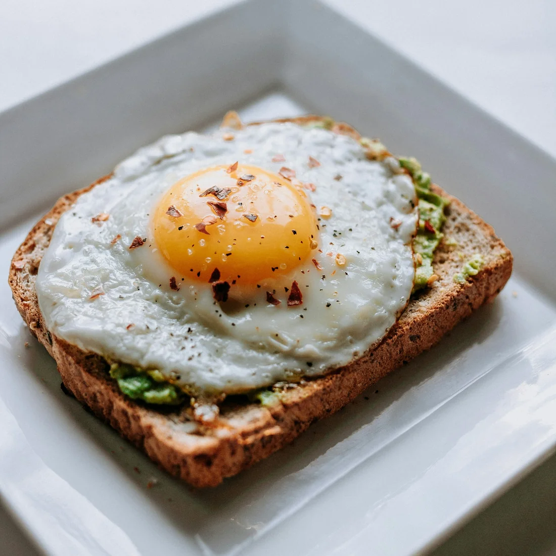 A sunny-side-up egg on avocado toast